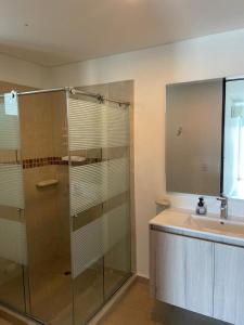 a bathroom with a glass shower and a sink at Niña Sol in Santa Marta