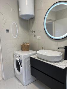 a bathroom with a washing machine and a mirror at Apartmani Rašić in Bibinje