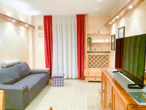 een woonkamer met een bank en een flatscreen-tv bij Asiago Centro Trilocale Condominio BELLOCCHIO con Garage WiFi PetFriendly in Asiago