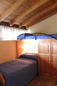 Albergue Turístico Via de la Plata في بانيوس دي مونتيمايور: غرفة نوم مع سرير بطابقين مع سرير أزرق