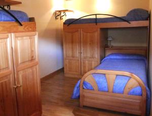 a bedroom with a bunk bed and a wooden cabinet at Albergue Turístico Via de la Plata in Baños de Montemayor