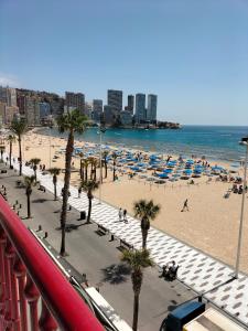 a beach with umbrellas and people on the beach at Las Damas 3B Beach Front - Pool & Parking in Benidorm