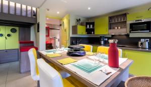a kitchen with a wooden table and yellow cabinets at Gîte des Pringets in Tresserves +12 photos