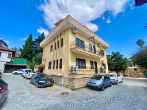 a building with cars parked in a parking lot at Ali Apart in Antalya