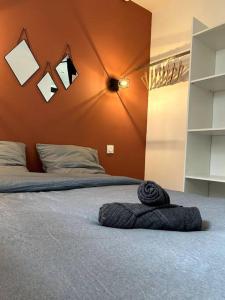 a bedroom with a bed with a black towel on it at Logement Neuf - Proximité Centre in Bourges