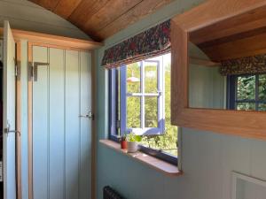 Habitación con ventana y alféizar en Novelist Shepherd's hut, en Beaminster