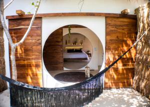 Habitación con cama y espejo redondo. en BH Hotel & Cenote Tulum - Adults Only en Tulum
