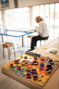 a woman sitting at a table with a colorful button board at Sotavento Beach Club in Costa Calma