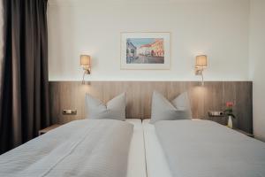 1 cama blanca grande en una habitación de hotel en Lechpark Hotel, en Untermeitingen