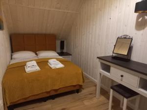 Un dormitorio con una cama y un escritorio con toallas. en Domek Relaks pod Śnieżką, en Miłków