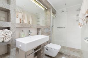 a white bathroom with a sink and a toilet at Elegant Apartments in Krakow +66 photos