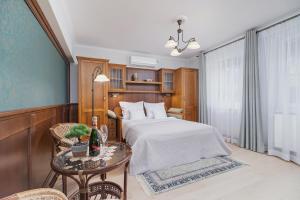 a bedroom with a bed and a table in a room at Elegant Apartments in Krakow