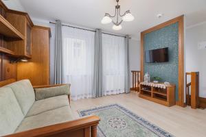a living room with a couch and a tv at Elegant Apartments in Krakow