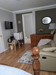 a living room with a couch and a mirror at Bear & Butterfly Bed and Breakfast in Gravenhurst