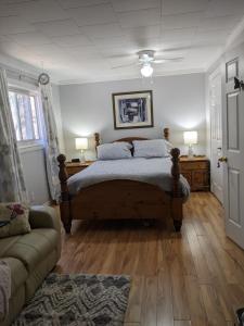 1 dormitorio con 1 cama y 1 sofá en Bear & Butterfly Bed and Breakfast en Gravenhurst