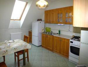 Family Homes - Bed & Bike Guesthouse في Łebcz: مطبخ مع طاولة وثلاجة بيضاء