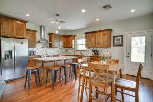 a kitchen with wooden cabinets and wooden tables and chairs at Lake Charles Vacation Rental - 3 Mi to Casinos! in Lake Charles
