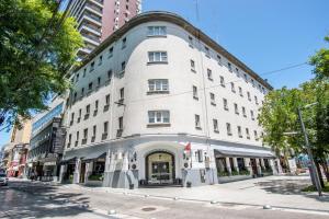 Un gran edificio blanco en una calle de la ciudad. en Castelar Hotel Santa Fe, en Santa Fe