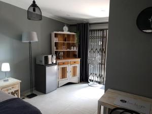 a room with a kitchen with a refrigerator and a microwave at Haleys Guest House in Benoni