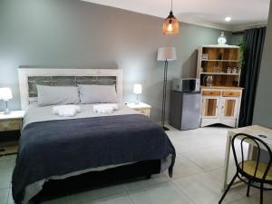 a bedroom with a large bed with two pillows at Haleys Guest House in Benoni
