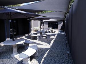 a row of picnic tables and umbrellas on a patio at Haleys Guest House in Benoni