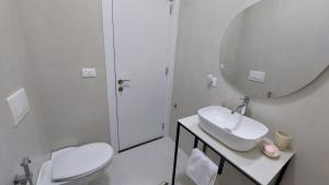 un bagno con un water, un lavandino e uno specchio di Amelja's Apartment a Shkodër Altre 9 foto