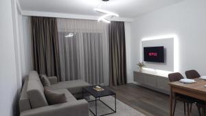 een woonkamer met een bank en een tafel bij Amelja's Apartment in Shkodër