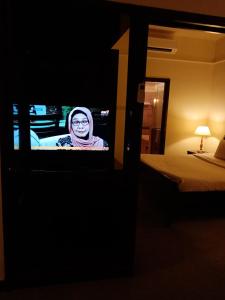 a woman is on a television in a hotel room at Ts service suites at Times Square in Kuala Lumpur