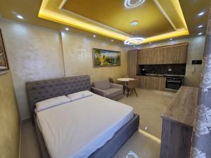 - une chambre avec un lit, un canapé et une table dans l'établissement NEWBORN Apartments Lungomare Vlore, à Vlorë