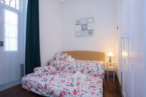 a small bedroom with a bed and a window at Patio da Foz - Appartement très accueillant centre-ville in Figueira da Foz