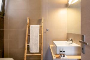 un baño con una escalera junto a un lavabo en Plakias Suites COCO-MAT Full Experience en Plakias