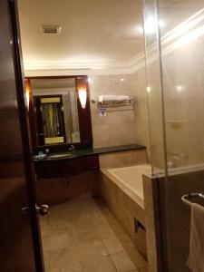 a bathroom with a tub and a sink and a mirror at Ts service suites at Times Square in Kuala Lumpur