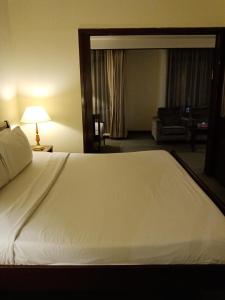 uma grande cama branca num quarto de hotel em Ts service suites at Times Square em Kuala Lumpur