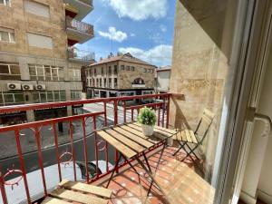 einen Balkon mit einer Holzbank und einer Topfpflanze in der Unterkunft VUT Correhuela in Salamanca