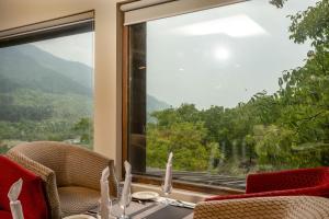 帕哈尔加姆The Chinar Resort & Spa, Pahalgam的带桌子和大窗户的餐厅 更多16张照片