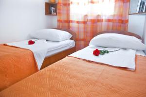 Dos camas en una habitación con dos rosas. en Apartments Superb View, en Dubrovnik