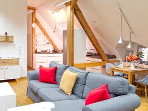 a living room with a blue couch and red pillows at BohnApartments Altstadt-Loft - Wasserbett - gratis Parkplatz - WLAN - Zentrum in Erfurt