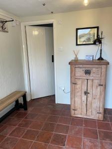 a room with a wooden cabinet and a bench at Elbury Lodge in Exeter