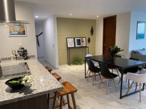 eine Küche und ein Wohnzimmer mit einem Tisch und Stühlen in der Unterkunft Elegante en zona financiera / Limpieza diaria in Guadalajara