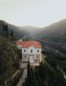 a white house with a red roof on a mountain at 1909 Guesthouse in Kalavrita