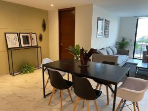 ein Wohnzimmer mit einem schwarzen Tisch und Stühlen in der Unterkunft Elegante en zona financiera / Limpieza diaria in Guadalajara