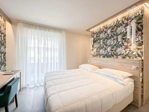 1 dormitorio con 1 cama grande y papel pintado con motivos florales en Bellettini Hotel en Milano Marittima