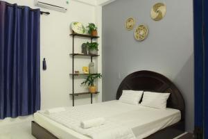 a bedroom with a bed and a blue wall at Dom Hostel and Bar in Hoi An
