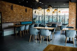 a restaurant with tables and chairs and a brick wall at Sonio Boutique Hotel in Mamaia