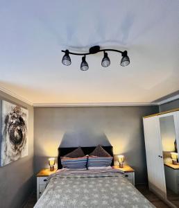 a bedroom with a bed with three lights above it at Zizi's House Gării 2 in Braşov