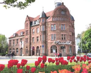 ein großes Backsteingebäude mit roten Blumen davor in der Unterkunft BohnApartments Altstadt-Loft - Wasserbett - gratis Parkplatz - WLAN - Zentrum in Erfurt