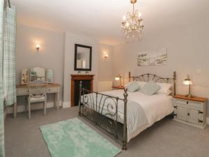 a bedroom with a bed and a desk and a mirror at Cornerside in Sidmouth