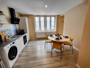 - une cuisine avec une table, une table et des chaises dans l'établissement Le Bellerade - Rez-de-chaussée tout confort, à Dunkerque