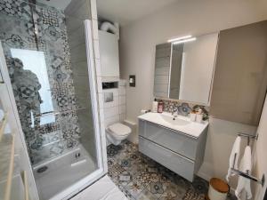 uma casa de banho com um chuveiro, um lavatório e um WC. em Le Bellerade - Rez-de-chaussée tout confort em Dunkerque