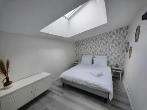 um quarto branco com uma cama e uma clarabóia em Le Bellerade - Rez-de-chaussée tout confort em Dunkerque